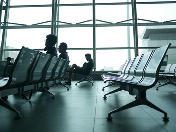 Men sitting on chair in airport