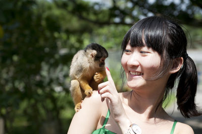 Portrait of woman playing with monkey