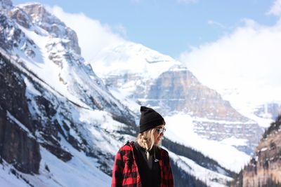 Man standing on snowcapped mountain against sky