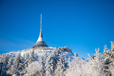 Low angle view of communication tower against blue sky