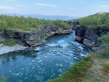 Scenic view of waterfall against sky