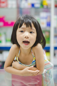 Close-up of cute girl with mouth open looking away in supermarket 