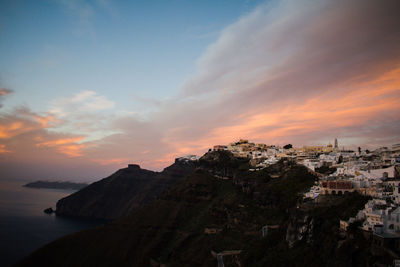 Scenic view of sea and buildings against sky during sunset