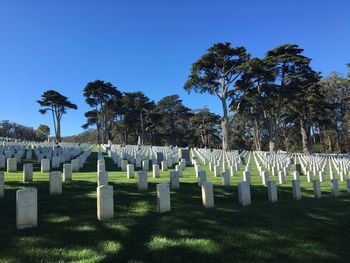 Tombstones in cemetery against blue sky