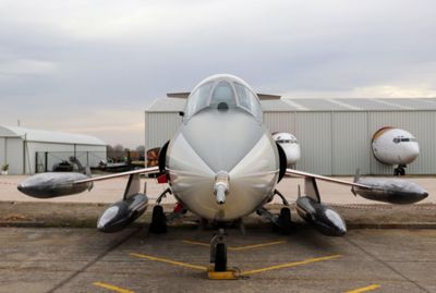 Fighter plane at airport runway against sky