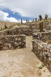 Stack of stone structure against cloudy sky