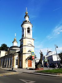 View of buildings in city against blue sky