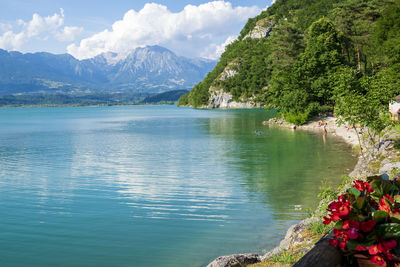 Scenic view of lake by mountains against sky