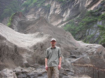 Portrait of man standing against rock formations