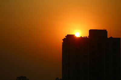 Silhouette of buildings against sky during sunset