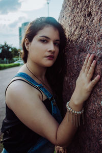 Beautiful woman standing by tree trunk