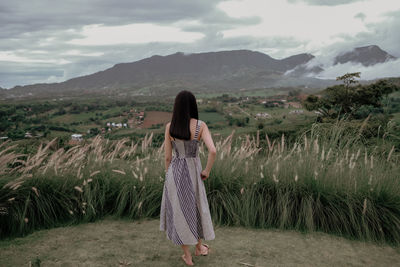 Full length of woman standing on land against sky