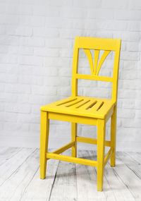 Empty yellow chair against wall at home