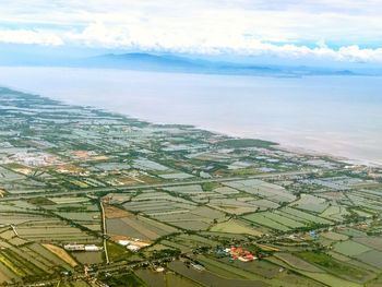 High angle view of town by sea against sky