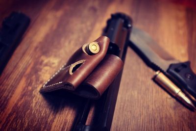 Close-up of bullets with gun on wooden table