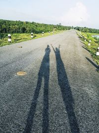 Shadow of man on road against sky