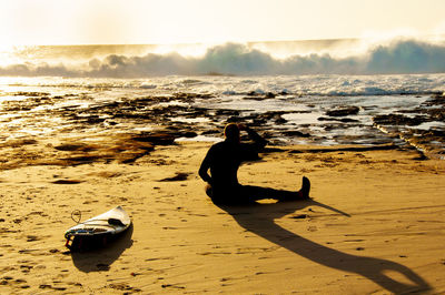 Rear view of man sitting at beach
