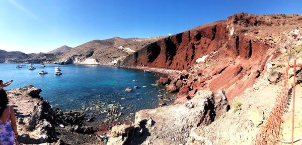 Scenic view of sea and rocks against clear blue sky