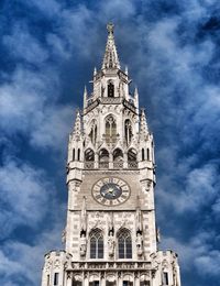 Low angle view of clock tower against cloudy sky