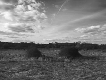 Scenic view of field against cloudy sky