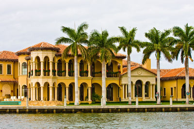 Exterior of building by palm trees against sky