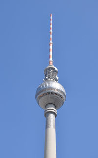 Low angle view of communications tower against blue sky