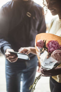 Midsection of woman holding mobile phone