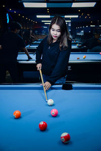 Young woman playing pool