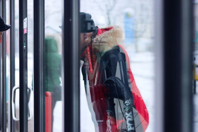 Rear view of boy looking through window