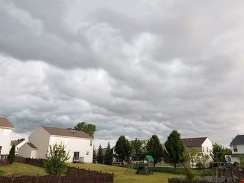 Houses against cloudy sky