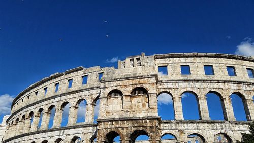 Low angle view of historical building against blue sky