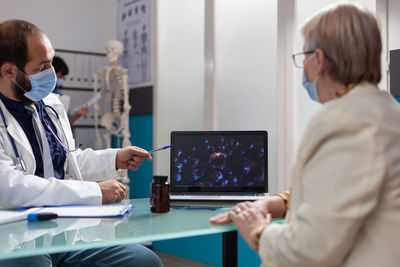 Doctor wearing mask examining patient in clinic