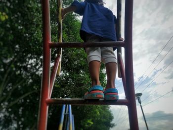 Low section of boy playing on slide at playground