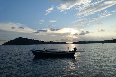 Boats in calm sea at sunset