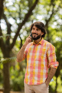 Young man at park on a beautiful sunny day with mobile phone.  working  leisure. green and nature 