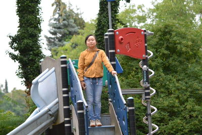 Portrait of woman standing on outdoor play equipment
