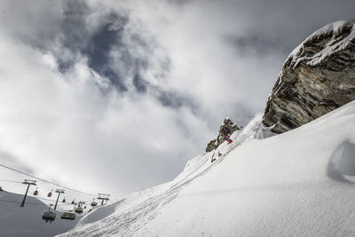 Man on snowcapped mountain against sky