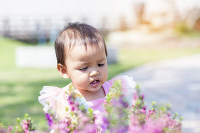 Portrait of cute baby girl on flowering plant