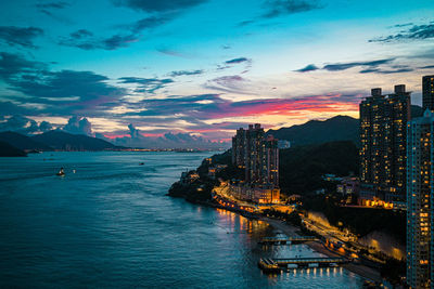 View of buildings at waterfront against cloudy sky