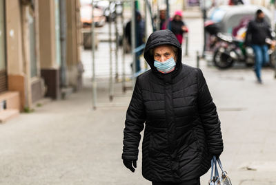 Man standing on street in city during winter