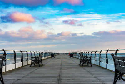 Pier over sea against sky during sunset