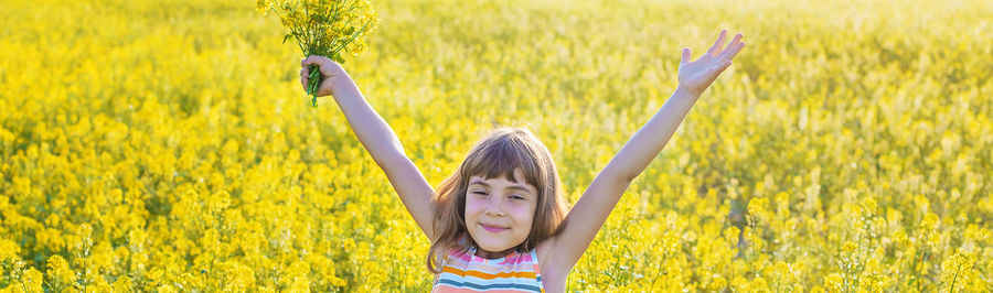 Cute girl holding flowers on field