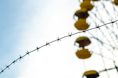 Low angle view of barbed wire against clear sky