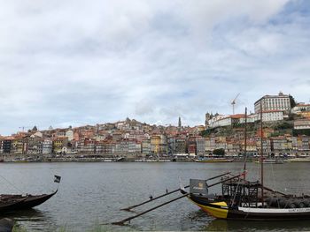 Boats moored in canal against buildings in city