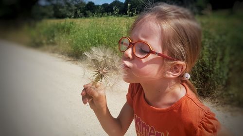 Close-up of girl holding dandelion flower