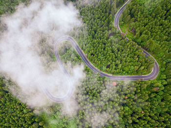 Aerial view of countryside road passing through the forest and mountain