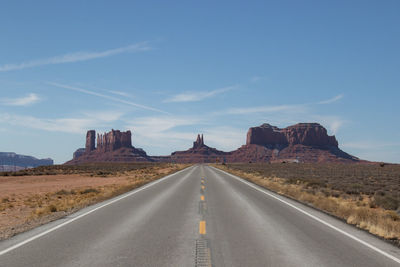 Empty road by mountain against sky