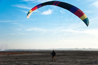 Person paragliding at beach