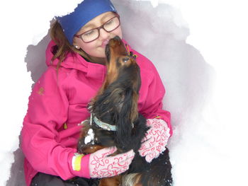 Portrait of a smiling young woman with snow during winter