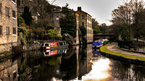 Boats in canal amidst buildings in city